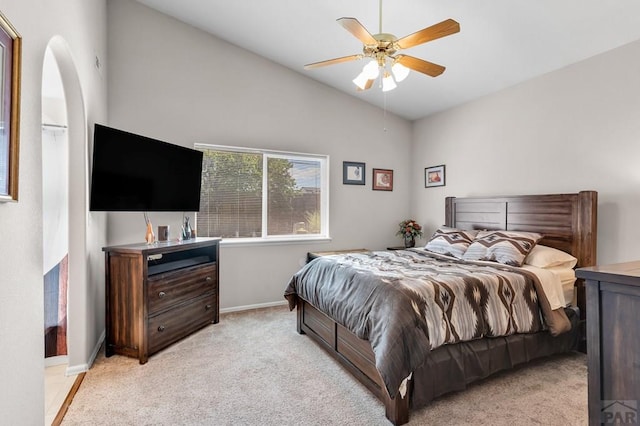 bedroom featuring ceiling fan, baseboards, vaulted ceiling, and light colored carpet