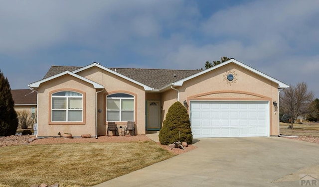 ranch-style home with a garage, driveway, a front lawn, and stucco siding