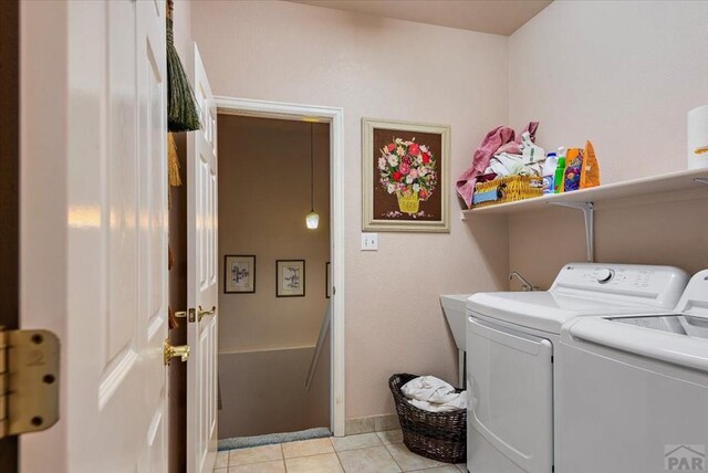 laundry room featuring laundry area, light tile patterned floors, baseboards, and independent washer and dryer