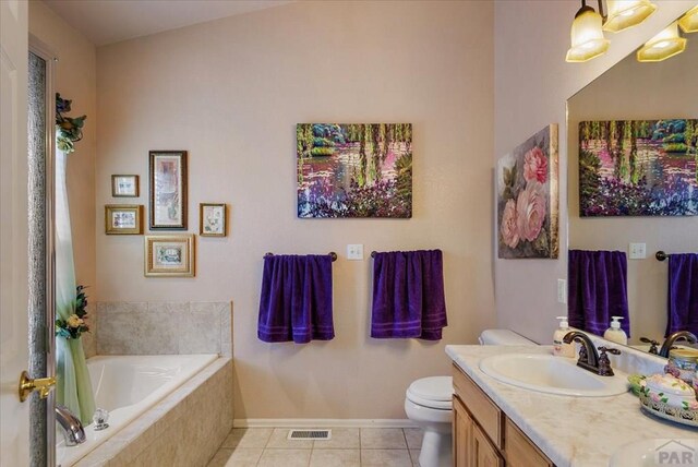 bathroom with a garden tub, toilet, vanity, visible vents, and tile patterned floors