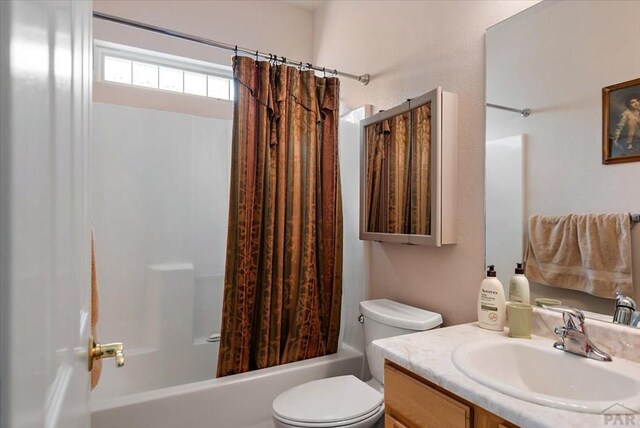 bathroom featuring toilet, shower / bath combo with shower curtain, and vanity