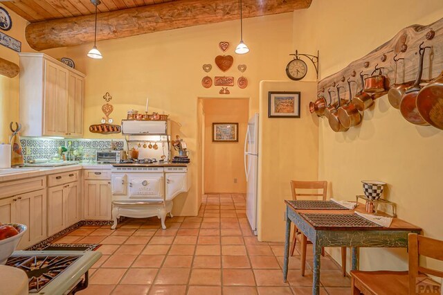 kitchen with light countertops, hanging light fixtures, backsplash, freestanding refrigerator, and wooden ceiling