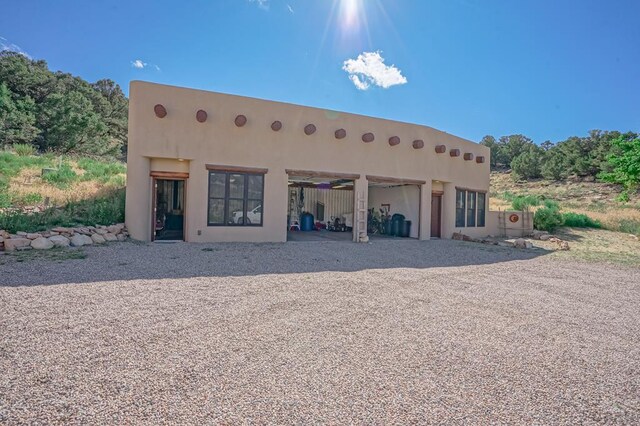 rear view of house featuring stucco siding