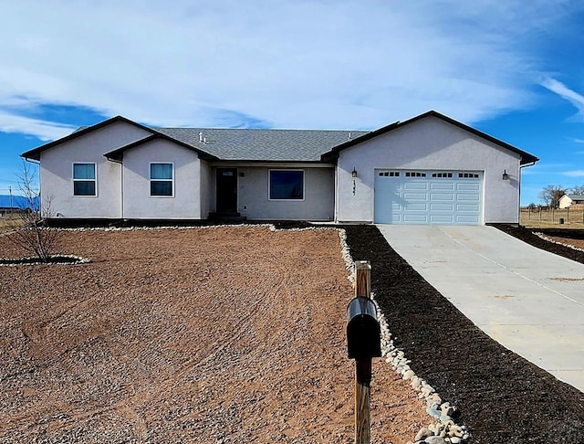 ranch-style home featuring a garage, concrete driveway, and stucco siding