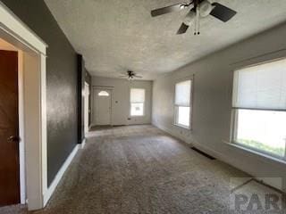 1102 Euclid Ave, Pueblo, CO 81004 - unfurnished living room with a ceiling fan, carpet, baseboards, and a textured ceiling