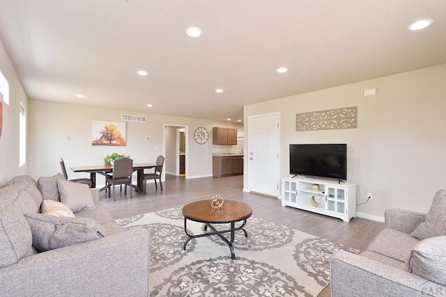 living room featuring visible vents, dark wood finished floors, and recessed lighting