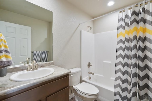 full bath with toilet, a textured wall, shower / tub combo with curtain, and vanity