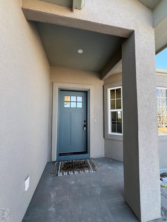 view of exterior entry featuring stucco siding