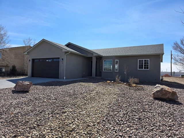 ranch-style home featuring stucco siding, concrete driveway, a garage, and roof with shingles