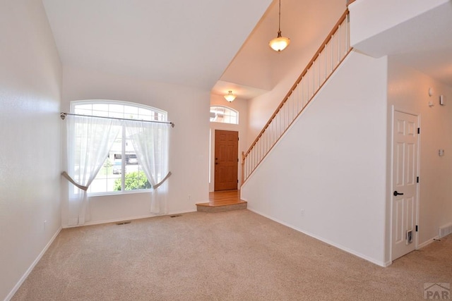 1135 Mount Estes Dr, Colorado Springs, CO 80921 - entryway featuring light colored carpet, plenty of natural light, a high ceiling, and stairway