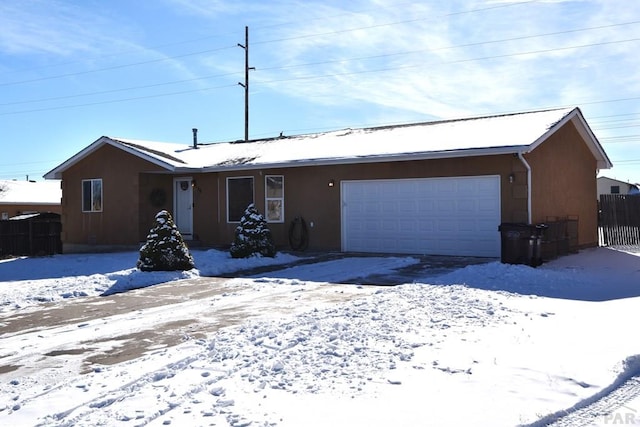 ranch-style home featuring a garage, fence, and stucco siding