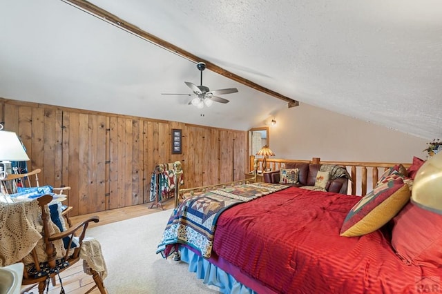 bedroom with wood walls, a textured ceiling, a ceiling fan, and lofted ceiling with beams