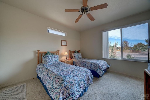 carpeted bedroom with ceiling fan and baseboards