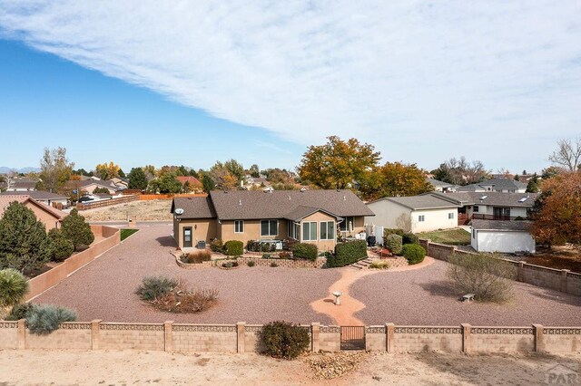 single story home featuring driveway, a gate, a fenced backyard, and a residential view