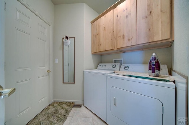 laundry room featuring light tile patterned floors, independent washer and dryer, cabinet space, and baseboards