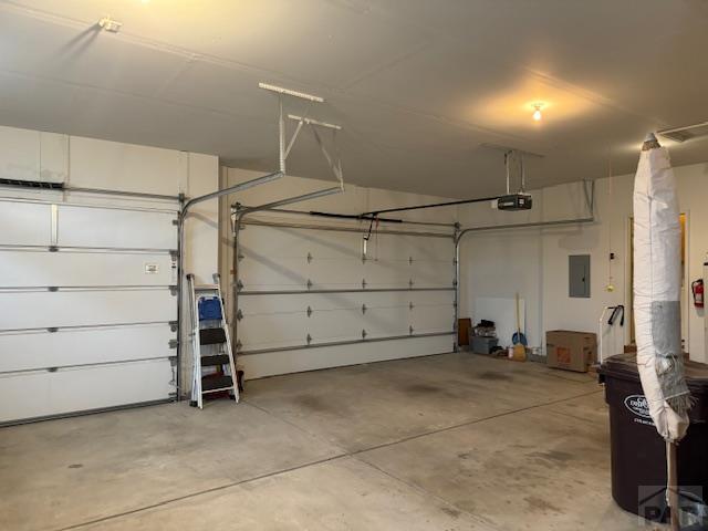 garage featuring electric panel and a garage door opener