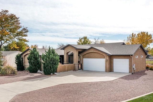 view of front of property with a garage, driveway, and stucco siding