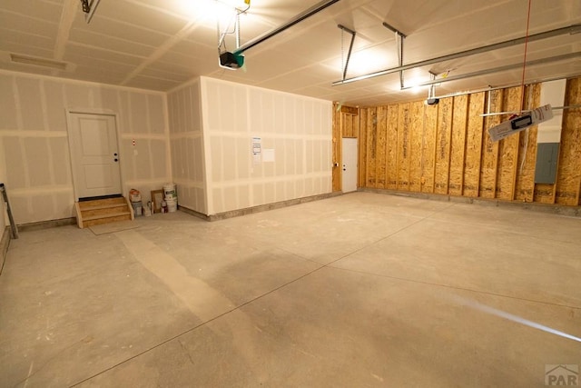 garage featuring electric panel and a garage door opener