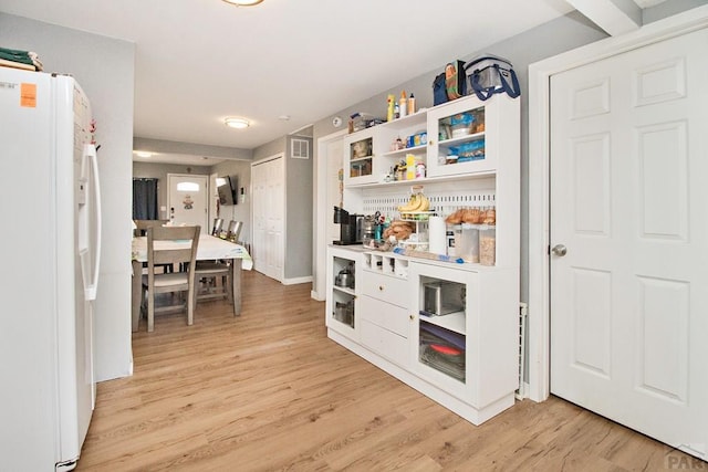 1710 E 3rd St, Pueblo, CO 81001 - kitchen featuring white refrigerator with ice dispenser, white cabinetry, open shelves, light wood-style floors, and visible vents