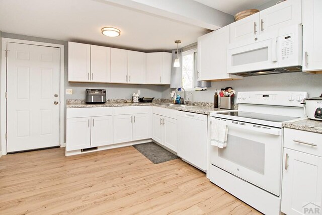 1710 E 3rd St, Pueblo, CO 81001 - kitchen featuring a sink, light wood-type flooring, white cabinetry, and white appliances