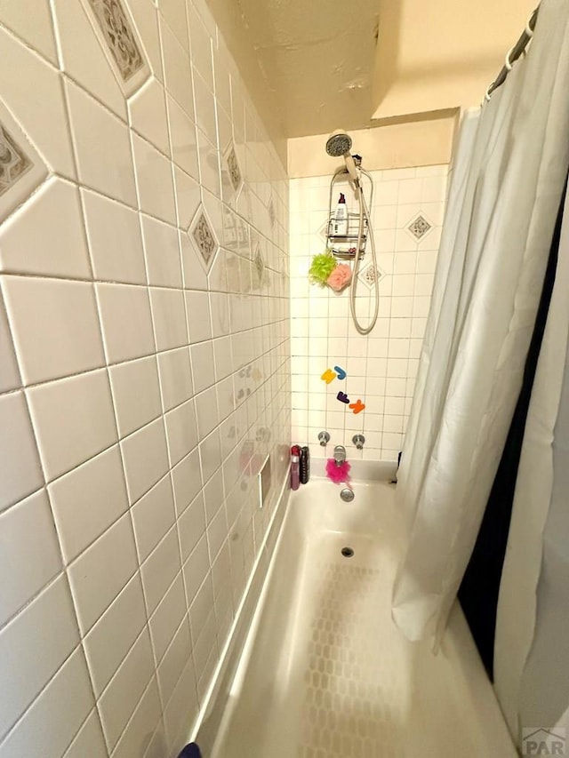 bathroom featuring a shower with curtain and tile walls