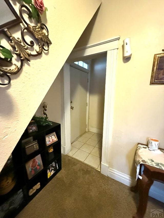 hall with light carpet and light tile patterned flooring