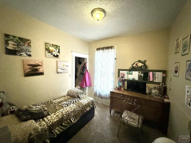 carpeted bedroom featuring a textured ceiling