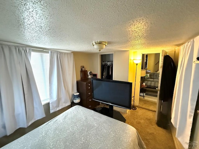 bedroom featuring a textured ceiling, carpet flooring, and a closet