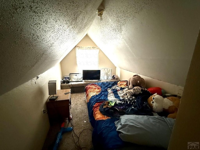 bedroom featuring a textured wall, a textured ceiling, vaulted ceiling, and carpet floors