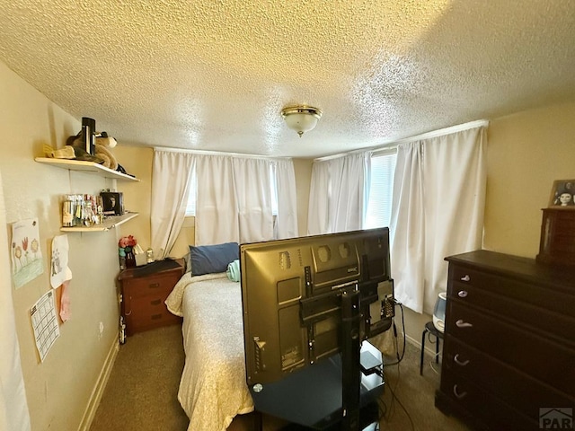 carpeted bedroom featuring a textured ceiling and baseboards