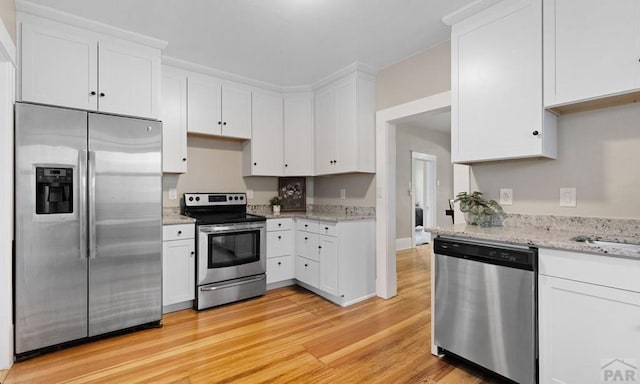 329 Washington St, Pueblo, CO 81004 - kitchen with appliances with stainless steel finishes, light wood finished floors, white cabinetry, and light stone counters