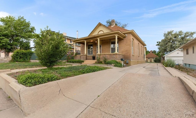 329 Washington St, Pueblo, CO 81004 - view of front of house featuring covered porch, brick siding, and driveway