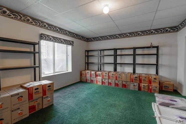 interior space with a paneled ceiling and dark carpet