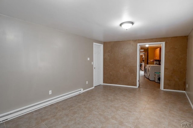 empty room featuring baseboard heating, washing machine and dryer, and baseboards