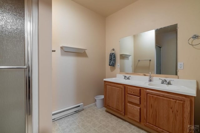 bathroom featuring a baseboard radiator, a sink, a shower with door, and tile patterned floors