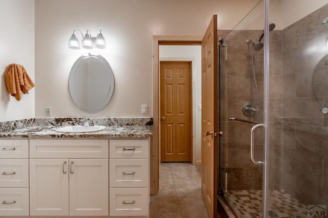 bathroom with a stall shower, tile patterned flooring, and vanity