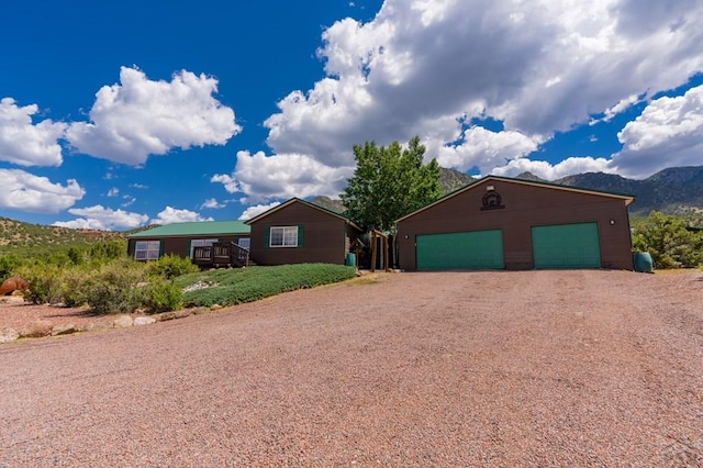 view of front of house with a detached garage, an outdoor structure, and a mountain view