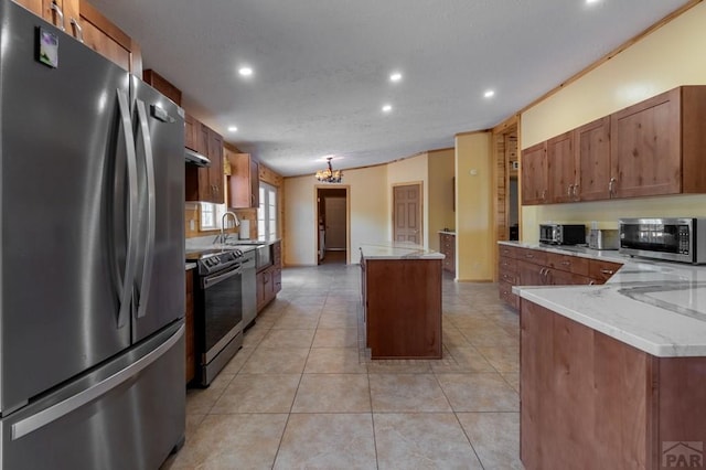 kitchen featuring brown cabinets, light tile patterned floors, stainless steel appliances, and a center island