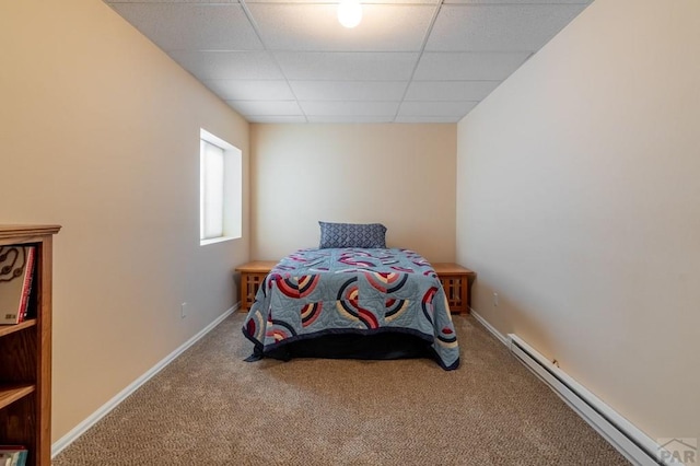 bedroom featuring a drop ceiling, a baseboard radiator, carpet flooring, and baseboards