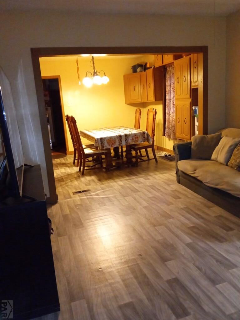 dining space featuring visible vents, a chandelier, and wood finished floors