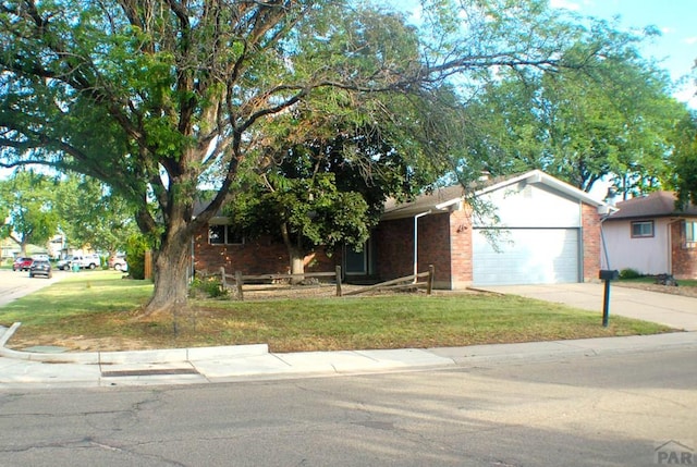 33 Regency Blvd, Pueblo, CO 81005 - view of front of home with an attached garage, a front yard, driveway, and brick siding