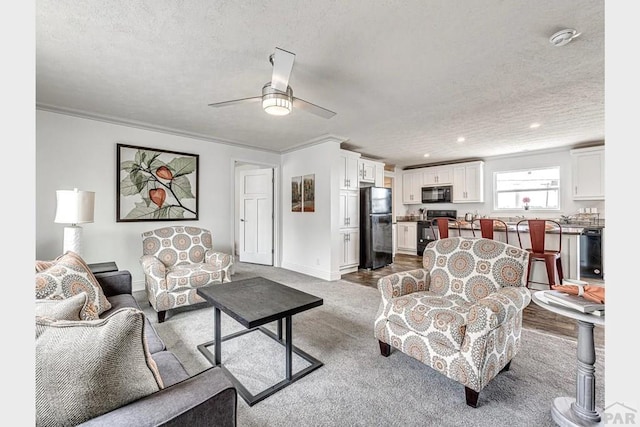 living room with ceiling fan, crown molding, baseboards, and a textured ceiling