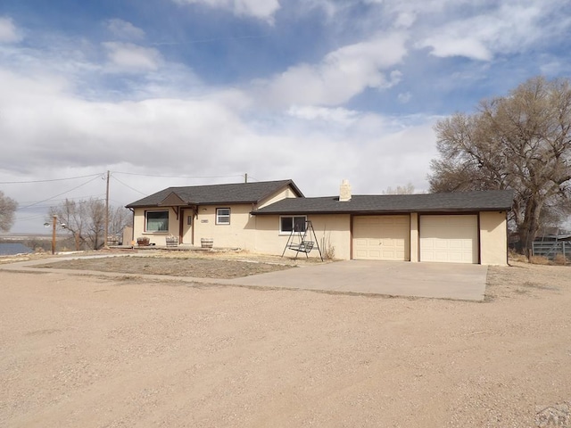 view of front of house with stucco siding, concrete driveway, and an attached garage