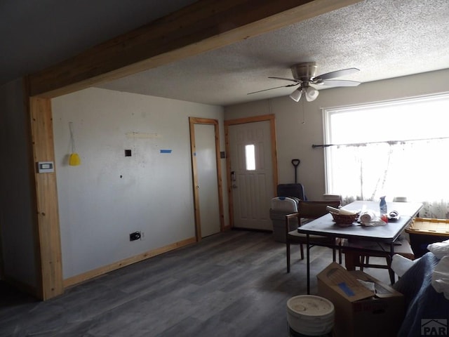 interior space featuring a ceiling fan, wood finished floors, baseboards, and a textured ceiling