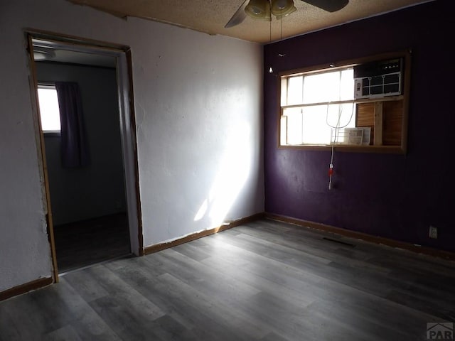 unfurnished bedroom featuring ceiling fan, baseboards, a textured ceiling, and wood finished floors