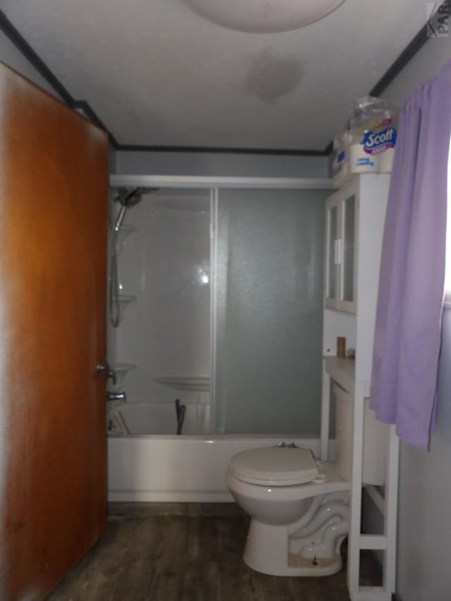 bathroom with shower / bathing tub combination, toilet, and wood finished floors