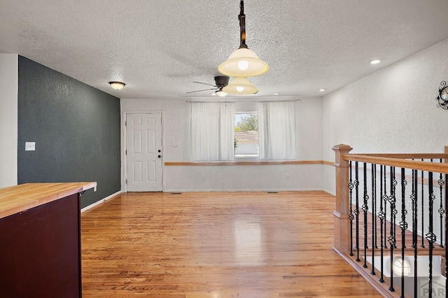 228 S Caddoa Dr, Pueblo West, CO 81007 - spare room with light wood-type flooring, ceiling fan, a textured ceiling, a textured wall, and baseboards