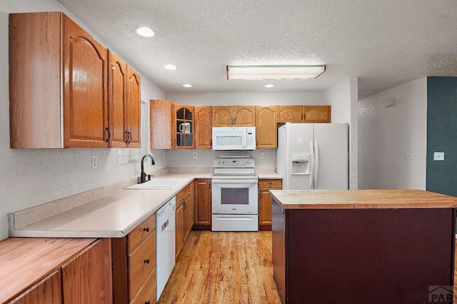 228 S Caddoa Dr, Pueblo West, CO 81007 - kitchen featuring white appliances, a sink, butcher block countertops, a textured ceiling, and a center island