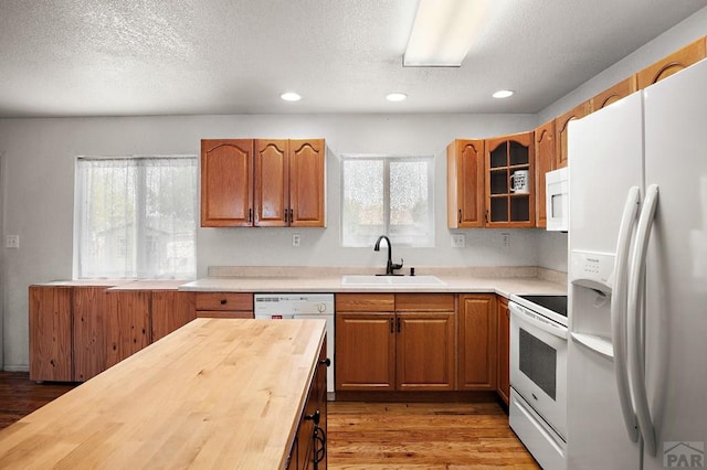 228 S Caddoa Dr, Pueblo West, CO 81007 - kitchen featuring a sink, white appliances, wood counters, a textured ceiling, and light wood finished floors