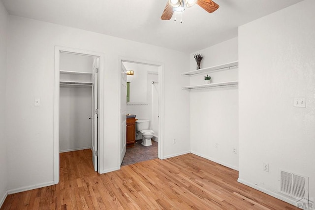 228 S Caddoa Dr, Pueblo West, CO 81007 - unfurnished bedroom featuring a spacious closet, a closet, light wood-style flooring, baseboards, and ensuite bath
